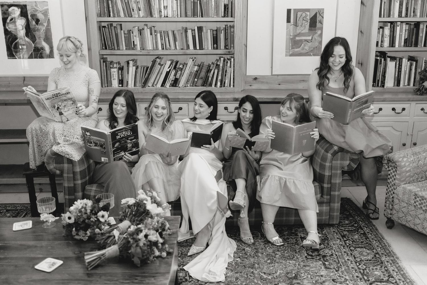 Casual gathering of wedding guests relaxing in a room with bookshelves.