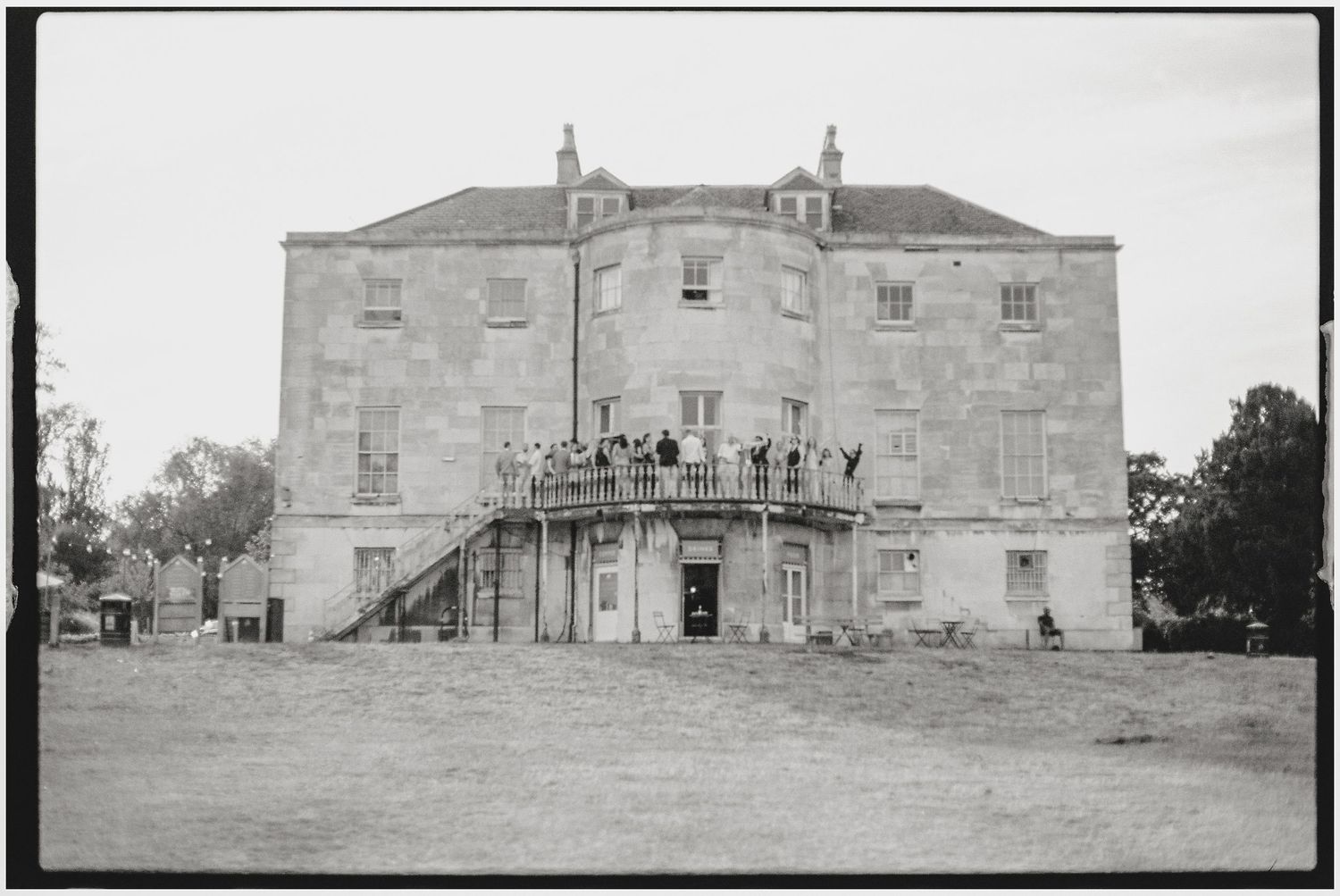 A panoramic black and white view of a historic mansion exterior.