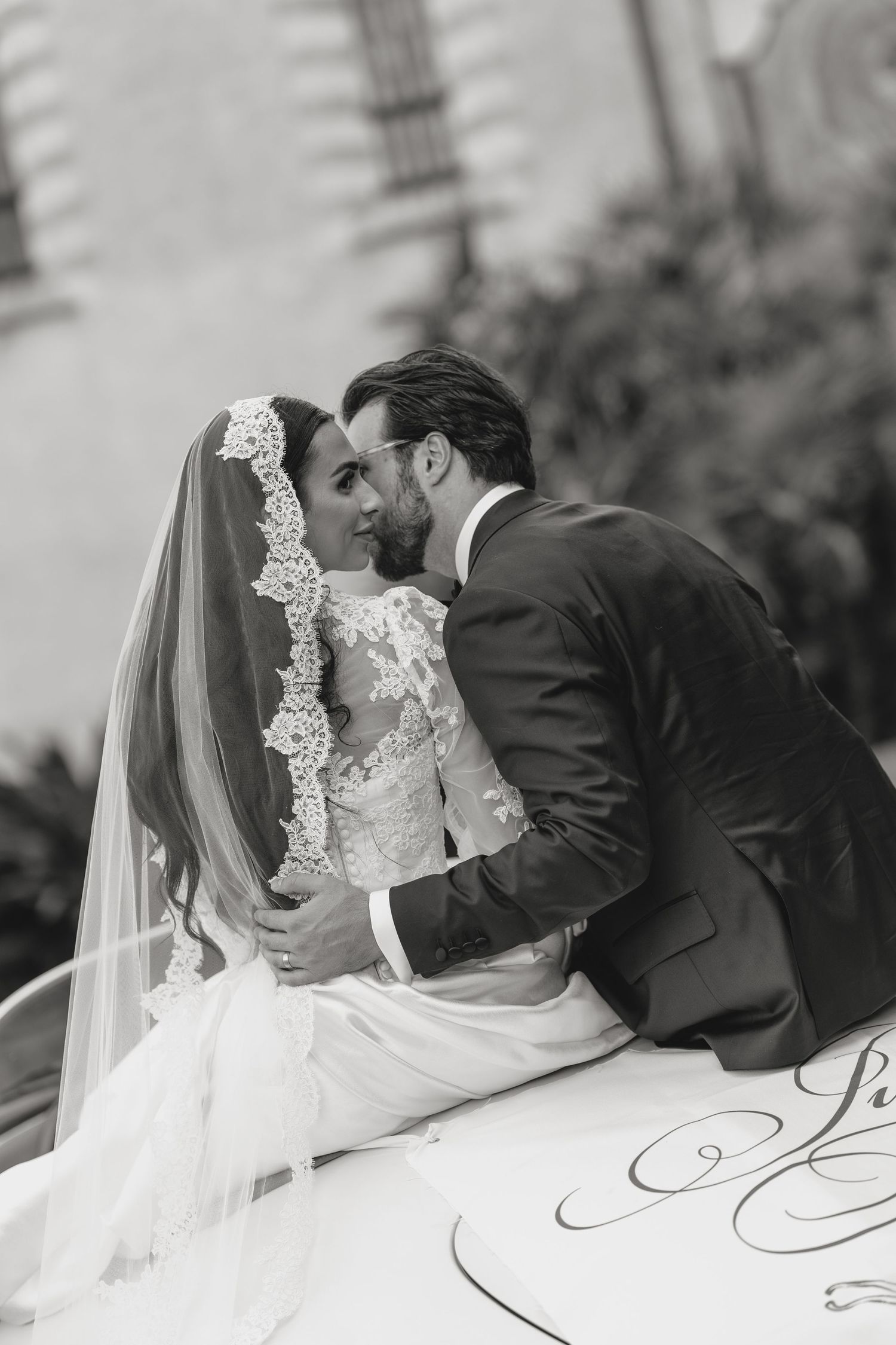 Romantic black and white wedding portrait against an elegant backdrop.