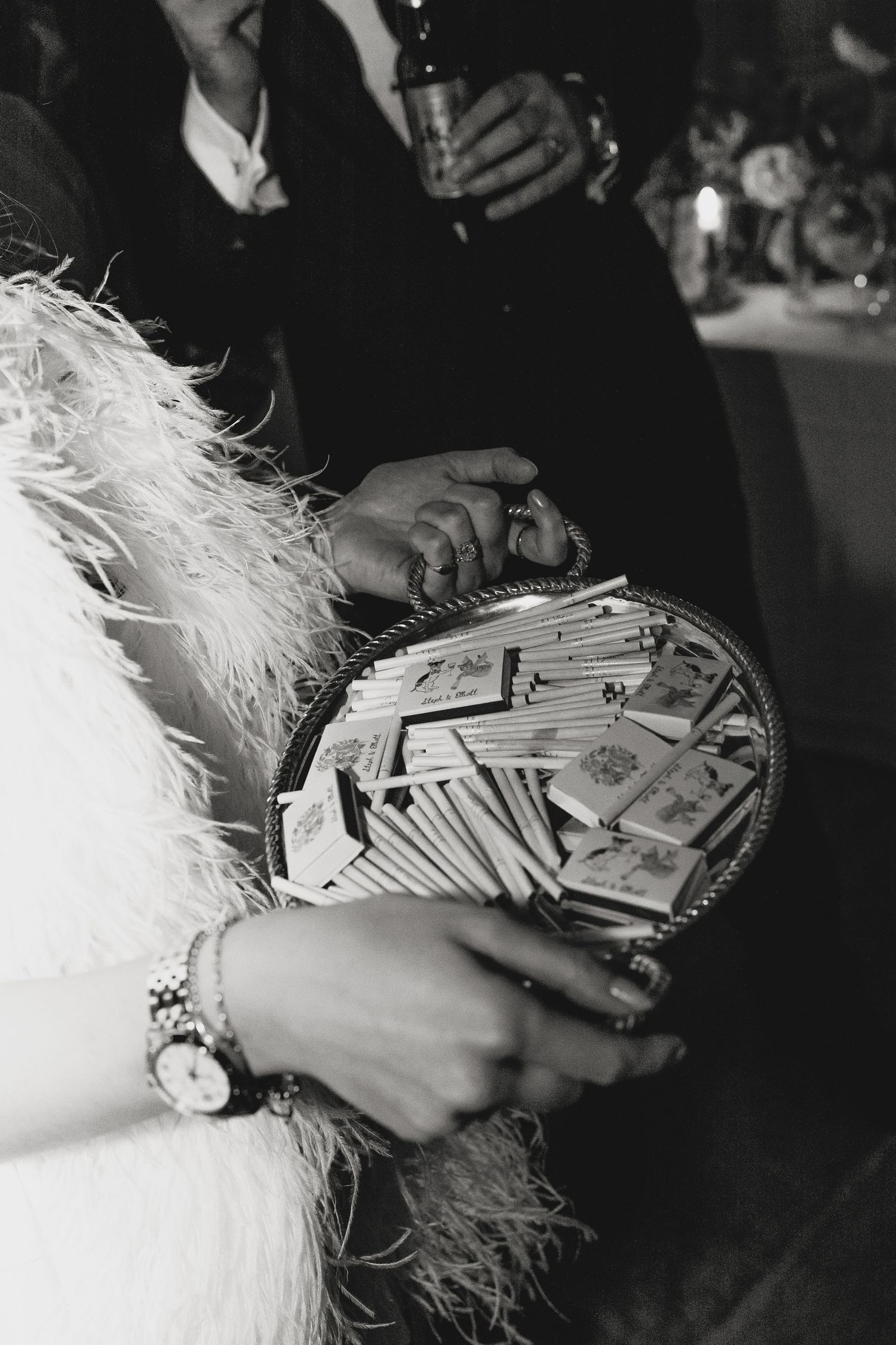Close-up of hands holding playing cards with feathered details visible.