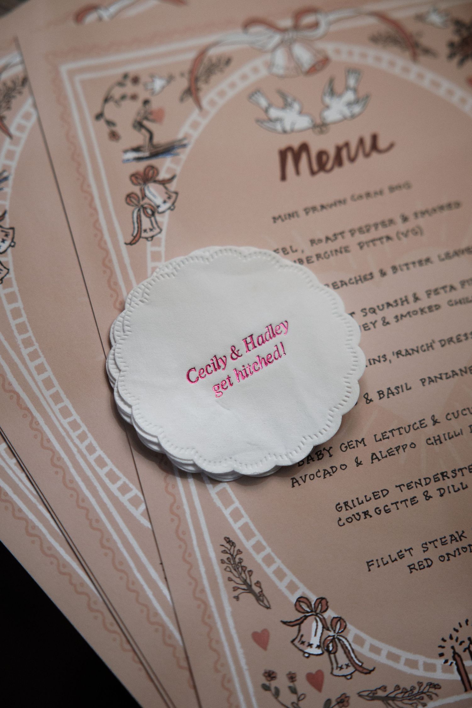 Wedding menu cards with decorative white doilies and pink text.