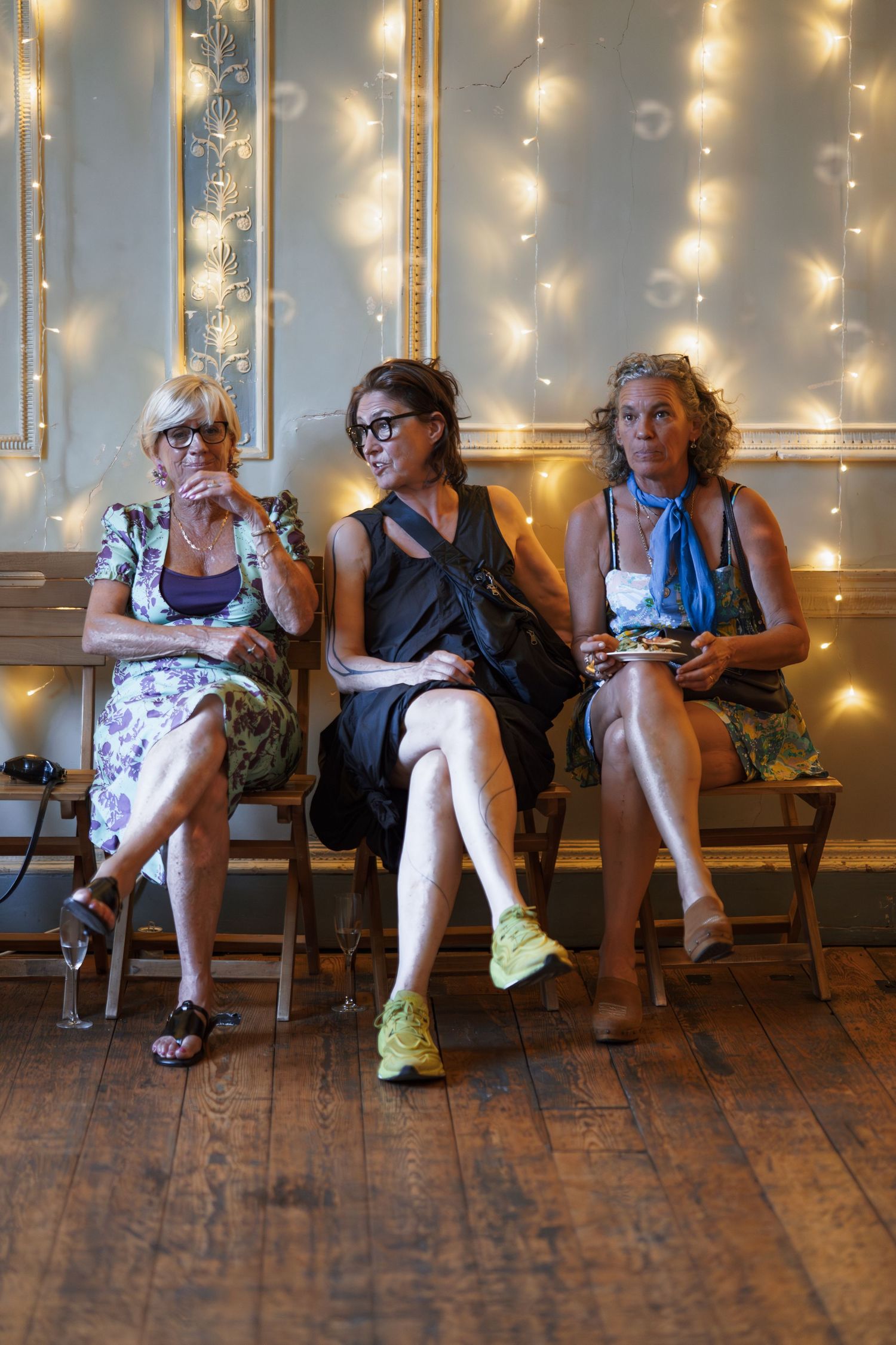 A sequence of candid moments showing guests seated on wooden chairs against a wall with twinkling lights.