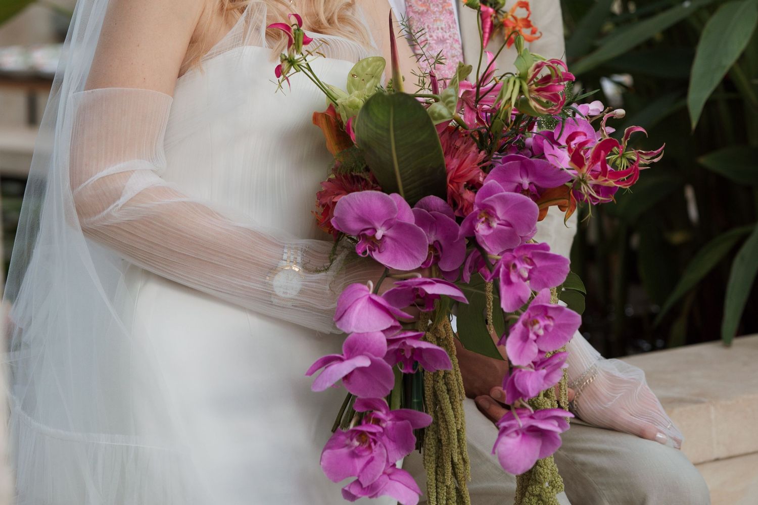 Vibrant purple orchids cascade down as part of an elegant wedding bouquet.