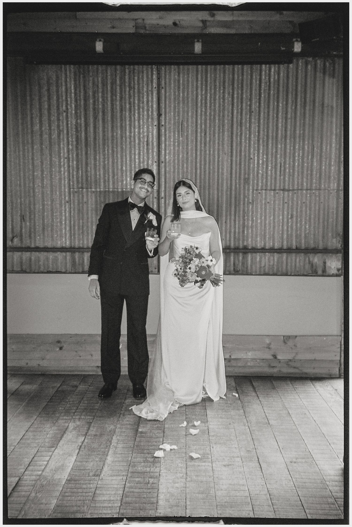 Vintage black and white wedding portraits in front of rustic wooden backdrop.