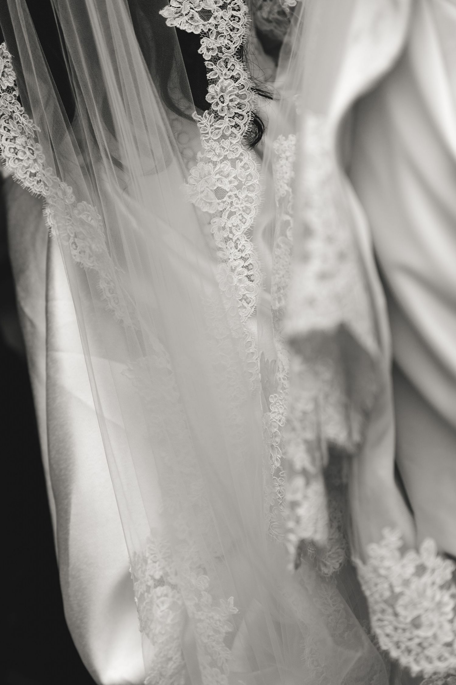Close-up detail of delicate lace trim on a white wedding veil.