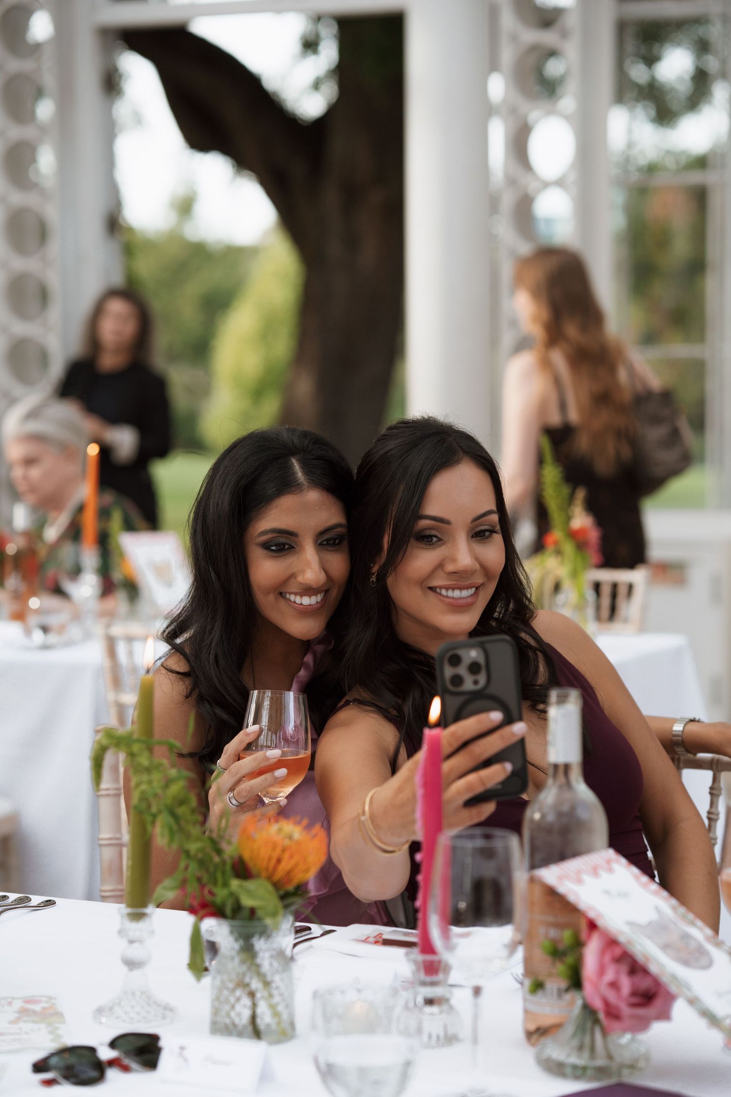 Wedding reception table set with guests enjoying drinks and conversation.