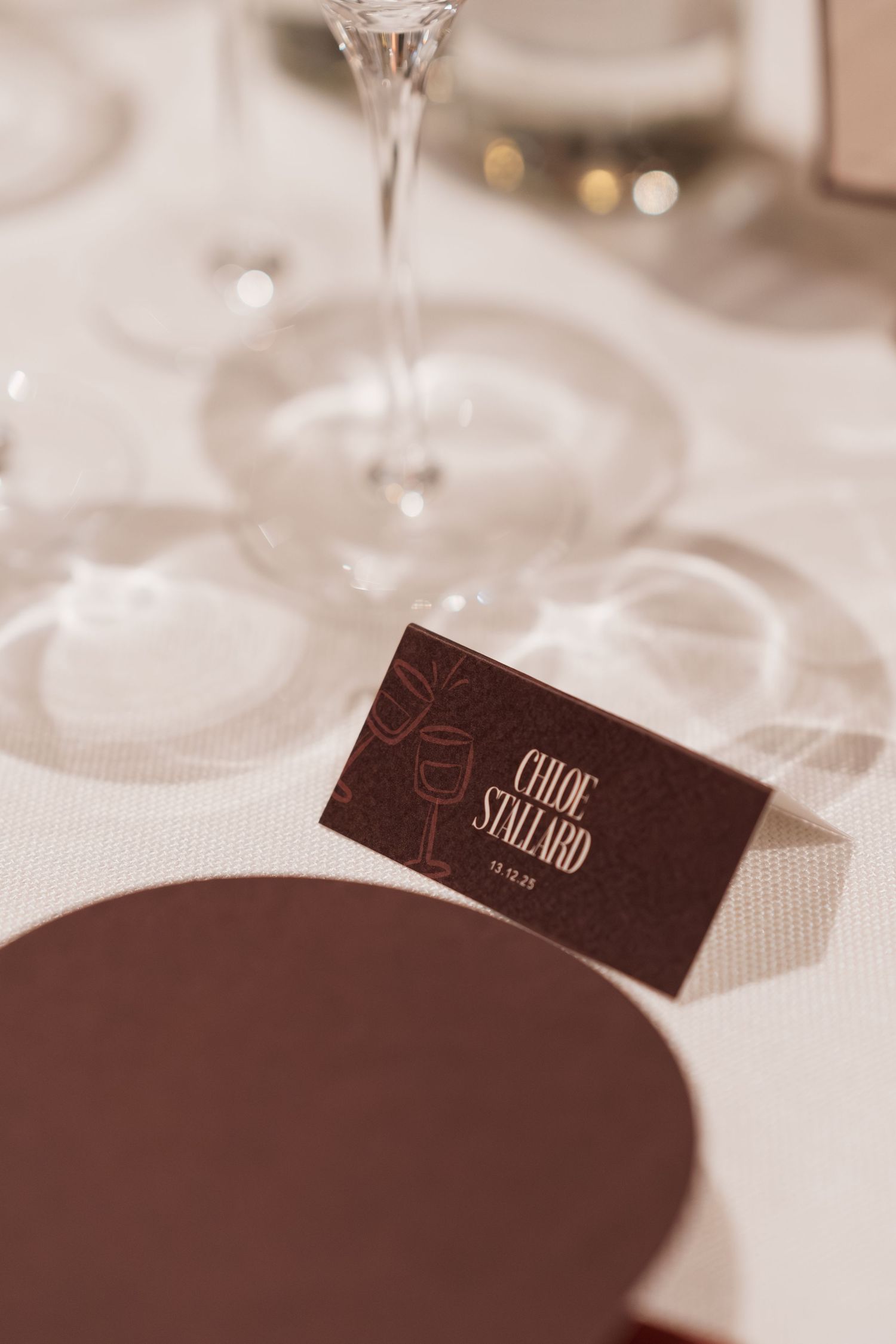 Close-up of embossed event cards on white tablecloth with soft focus.