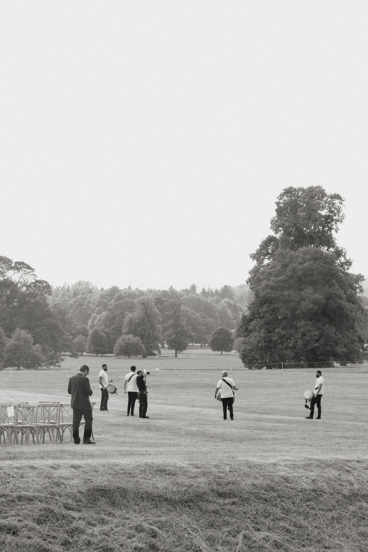 People scattered across a vast grassy field during an outdoor event.