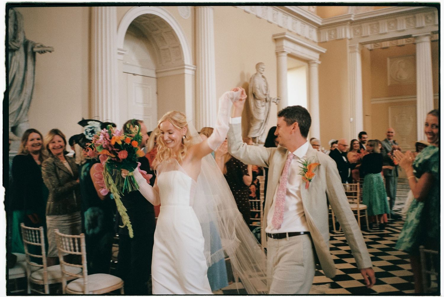 Celebration in a grand hall with black and white checkered floors.