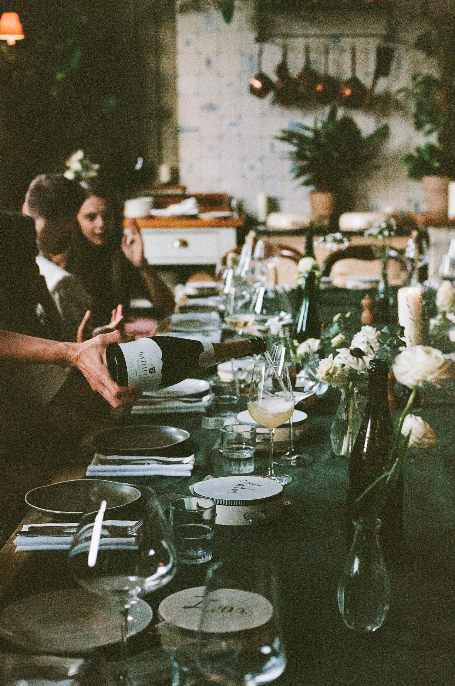 Elegant table settings with wine glasses and floral centerpieces at wedding reception.