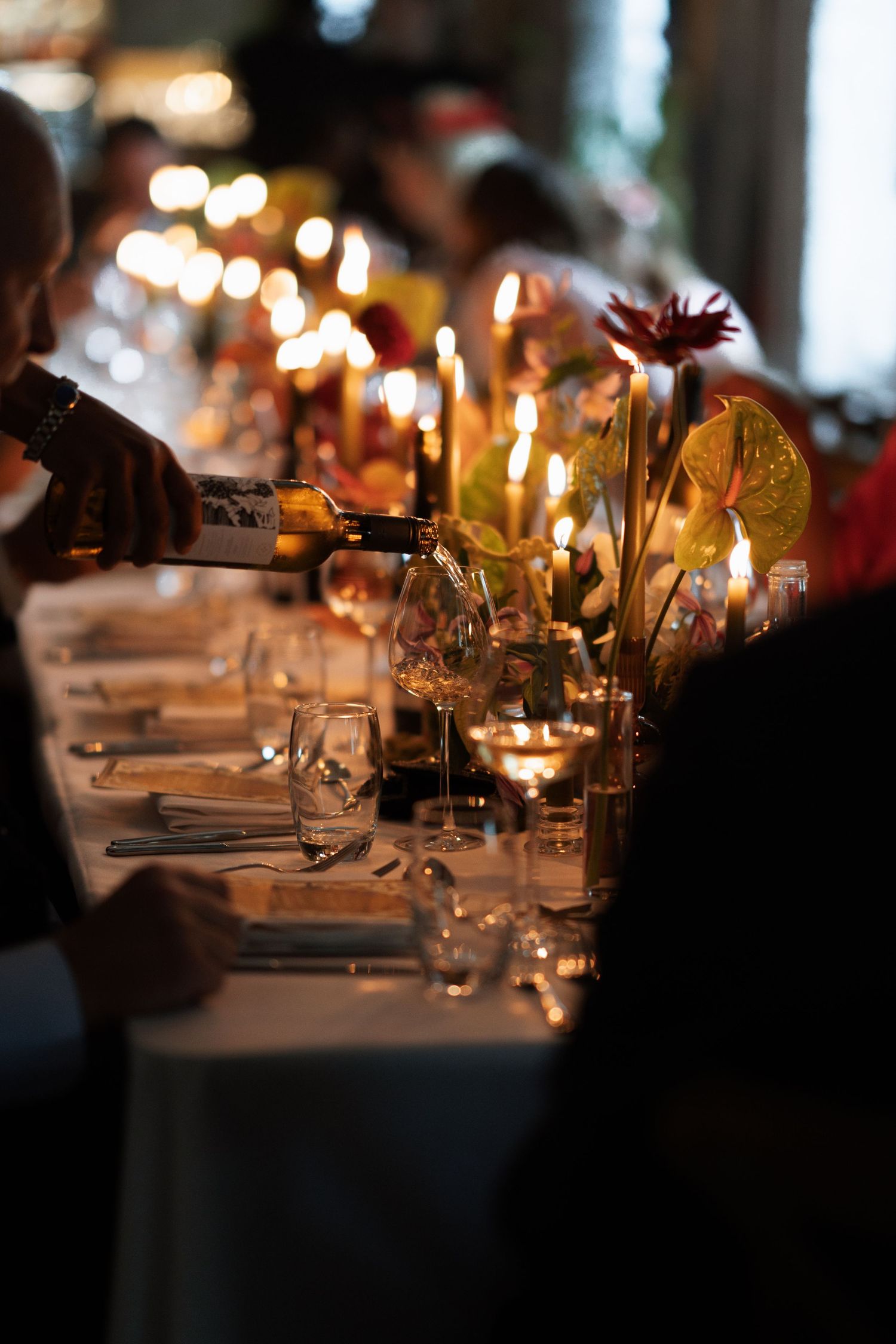 Elegant candlelit table settings at a formal dinner event with glowing ambient lighting.