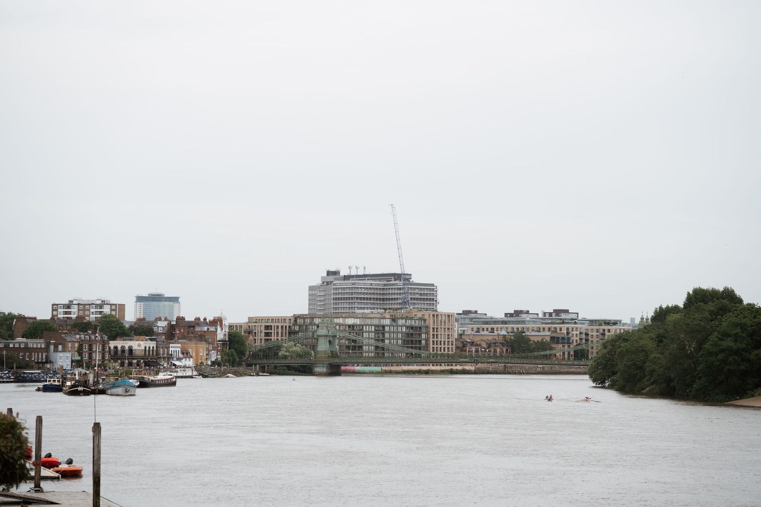 Panoramic view of a waterfront cityscape with boats and buildings.