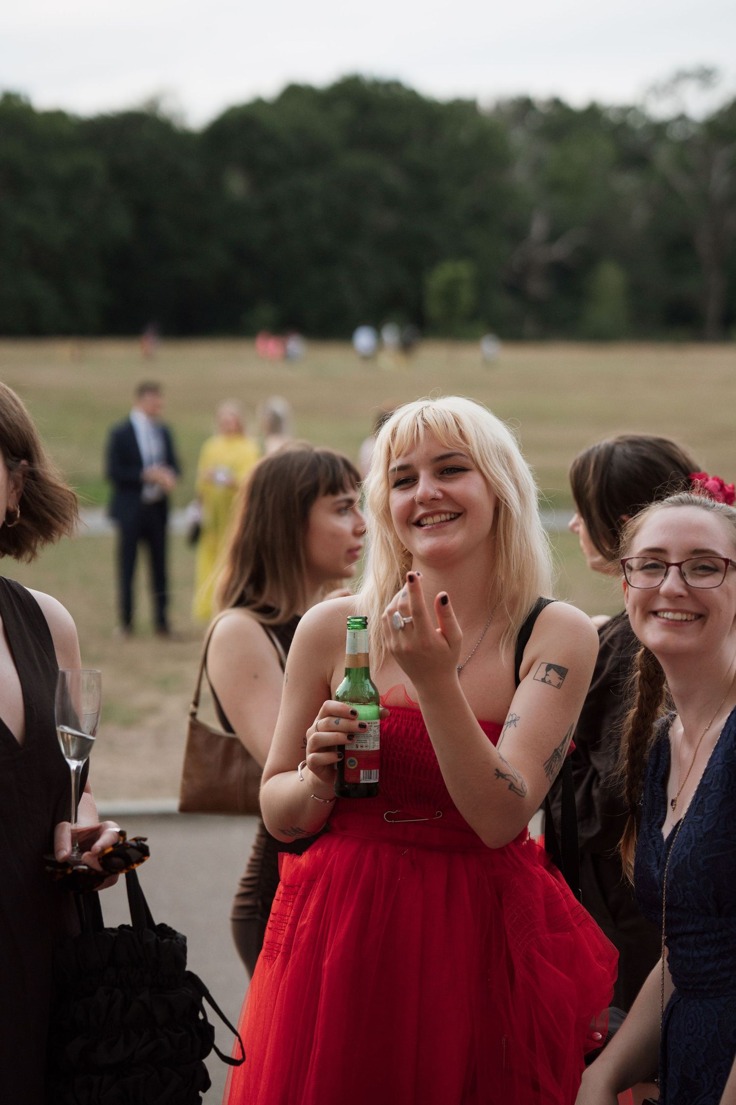 A group of wedding guests enjoying drinks and conversation at an outdoor reception.