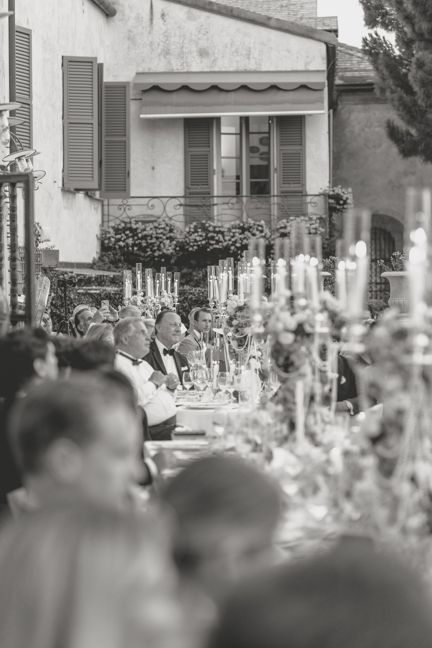 Wedding reception tables set with crystal glasses and elegant decor in soft focus.