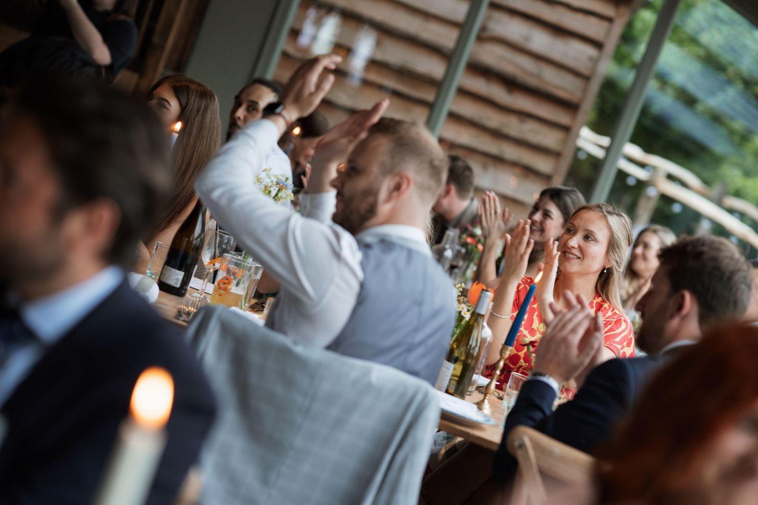 Wedding guests enjoying the celebration at a rustic indoor venue.