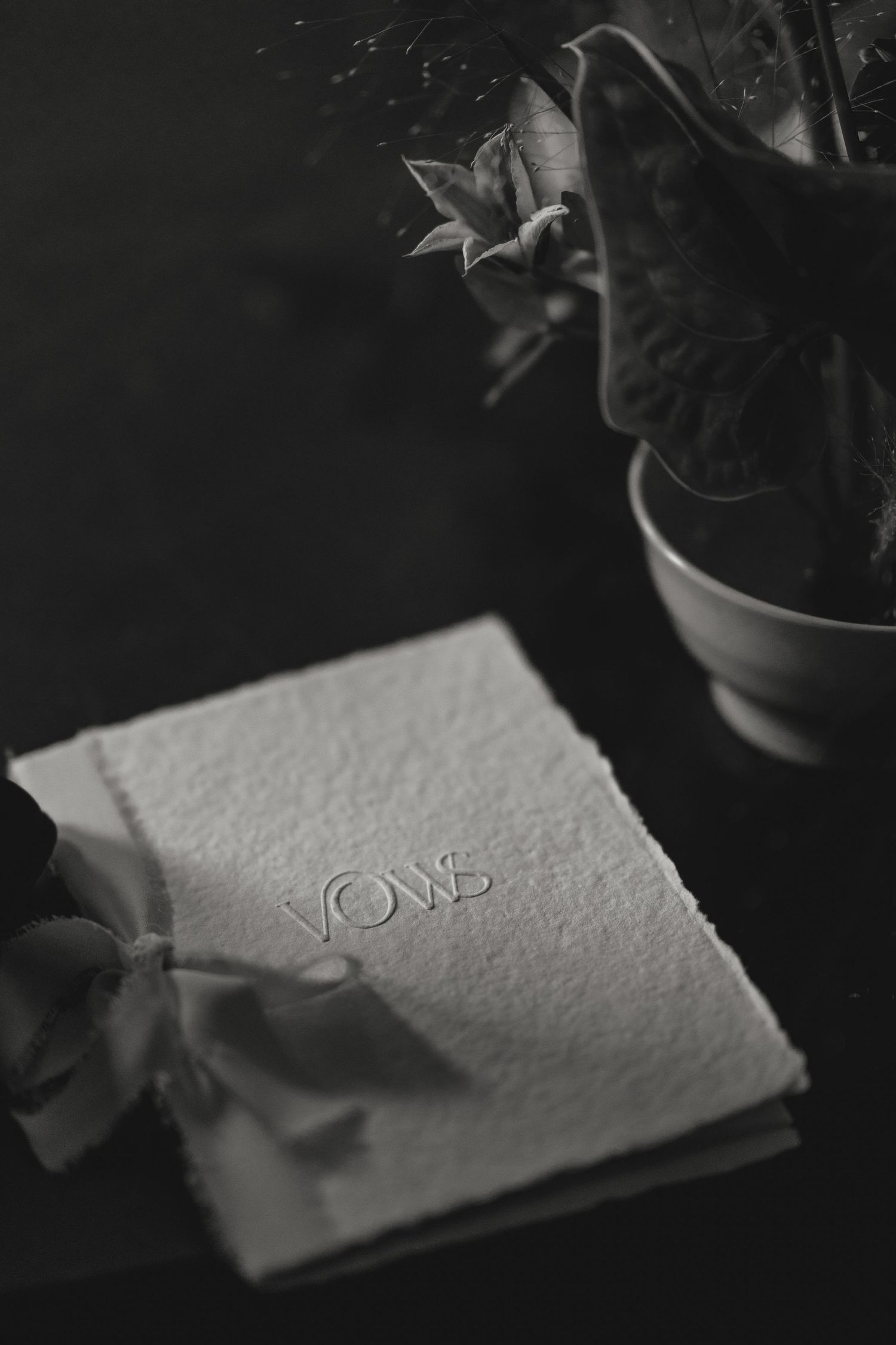 Black and white close-up of textured paper with embossed details.