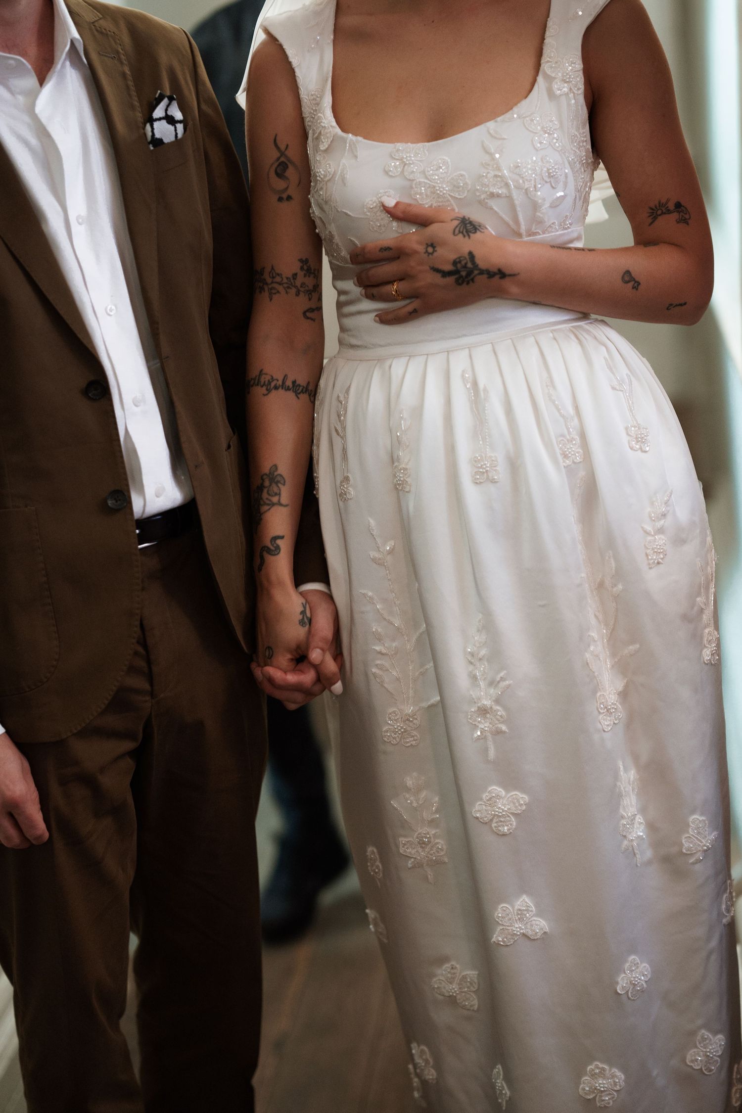 White lace wedding dress detail with delicate floral embroidery patterns.