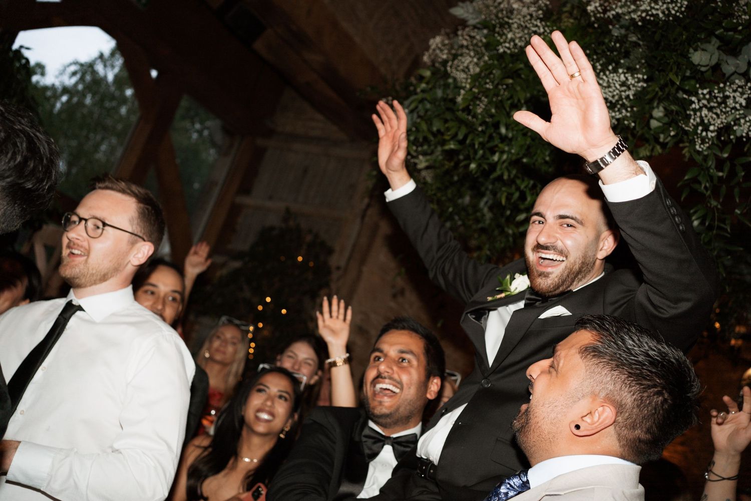 Celebratory dance moves at nighttime outdoor wedding reception.