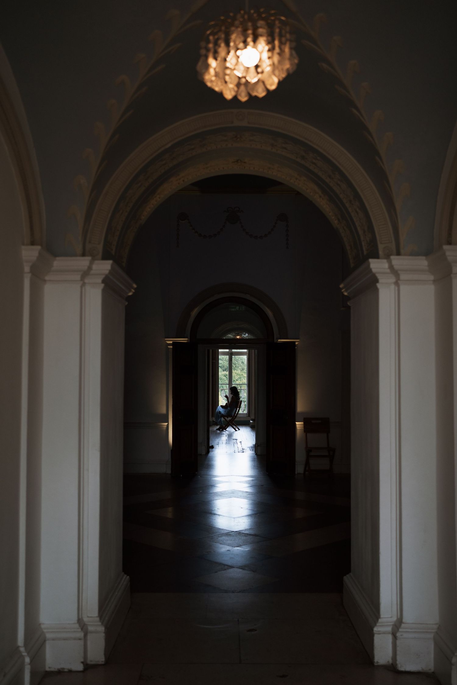 Long dark corridor with arched ceiling and dramatic lighting at the end.