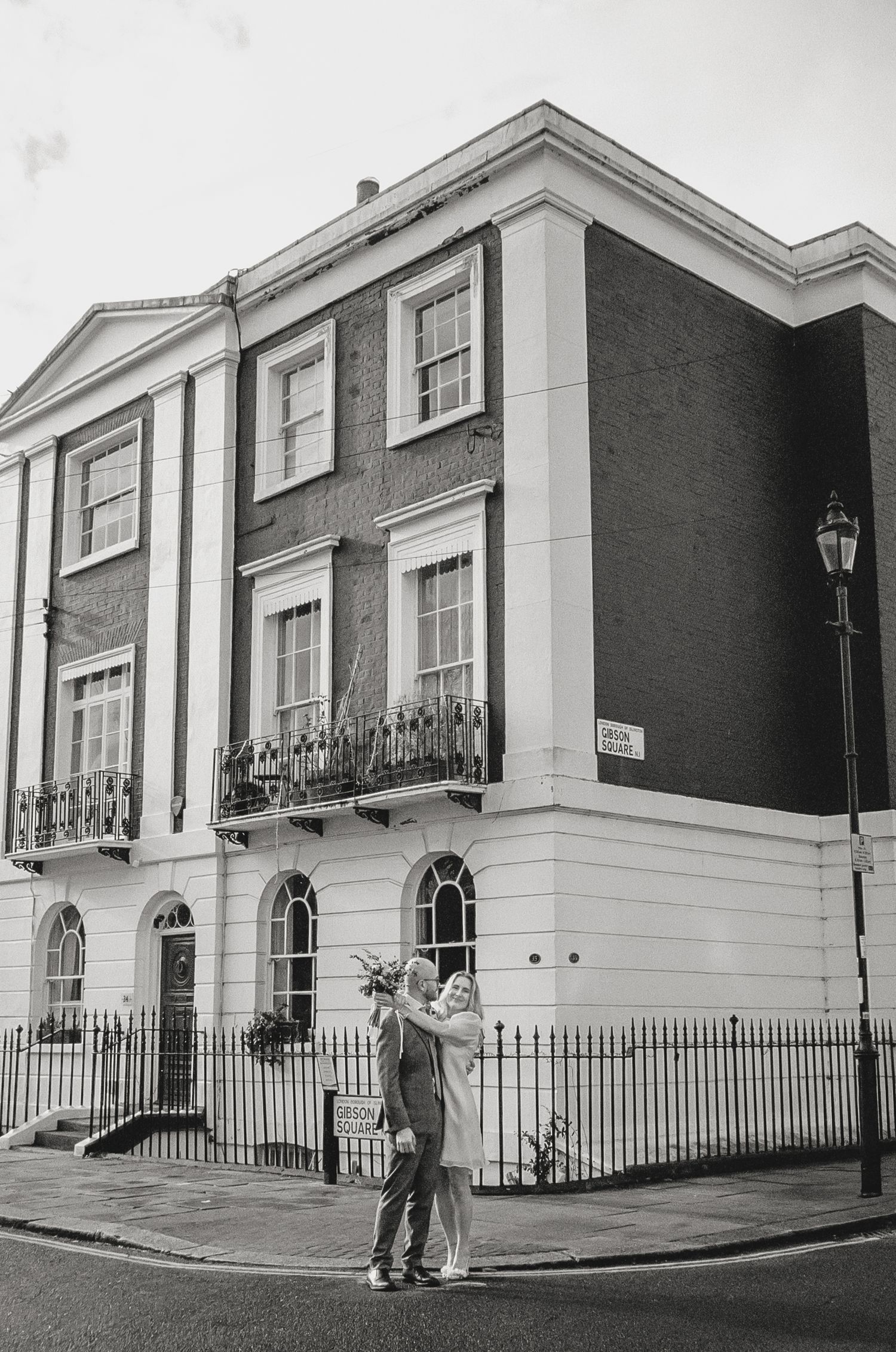 Black and white photo of classic Georgian townhouse with iron railings and white facade.