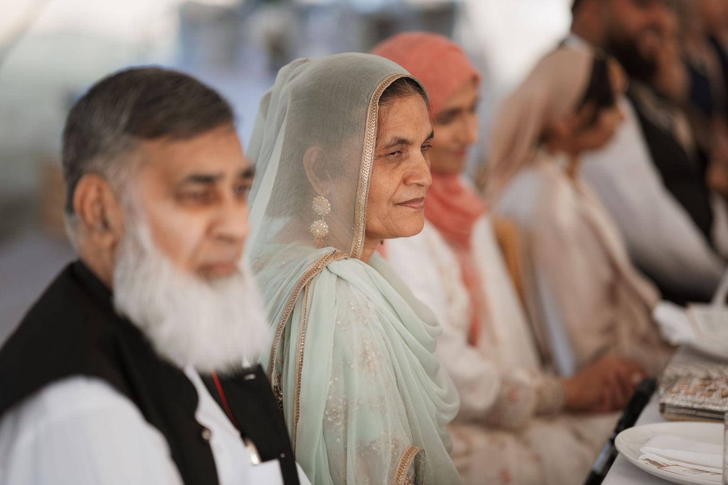 Wedding guests in traditional South Asian attire seated during ceremony.