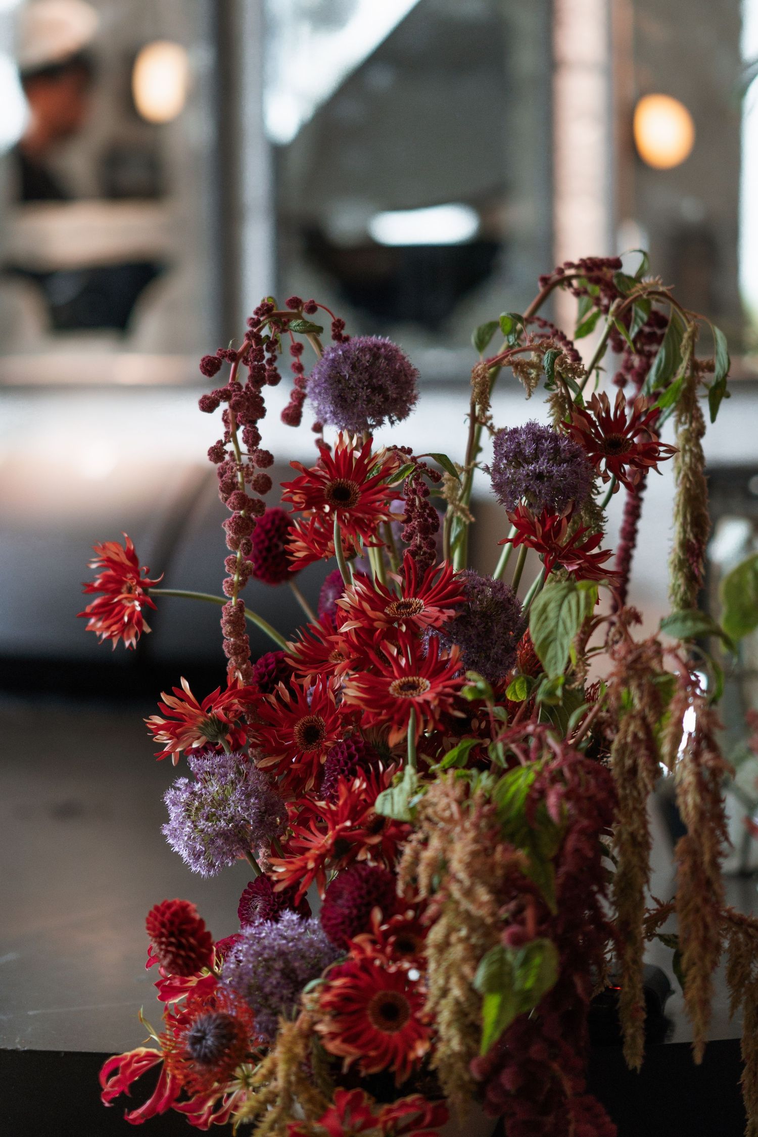 Arrangement of red and purple flowers in moody lighting.
