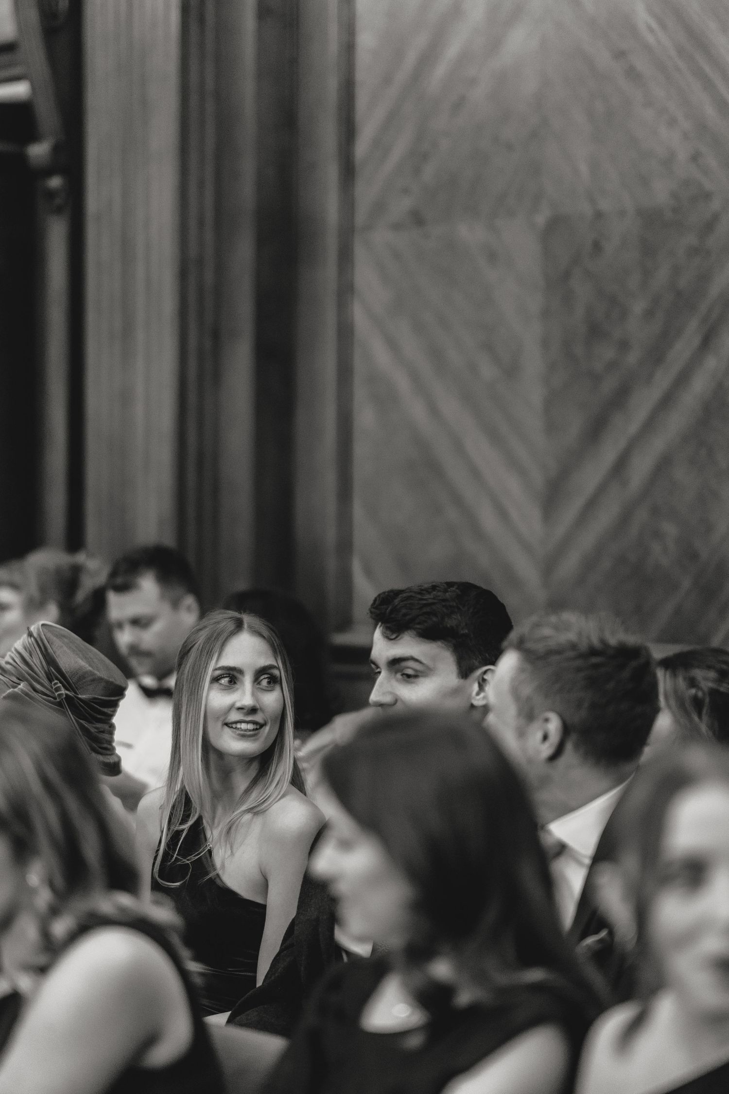 Wedding guests laugh and smile during a joyous celebration in an elegant venue.