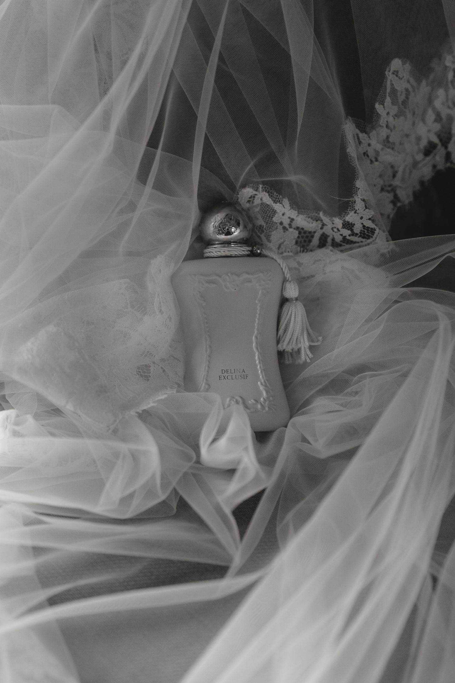 Perfume bottle draped in ethereal white tulle fabric in black and white.