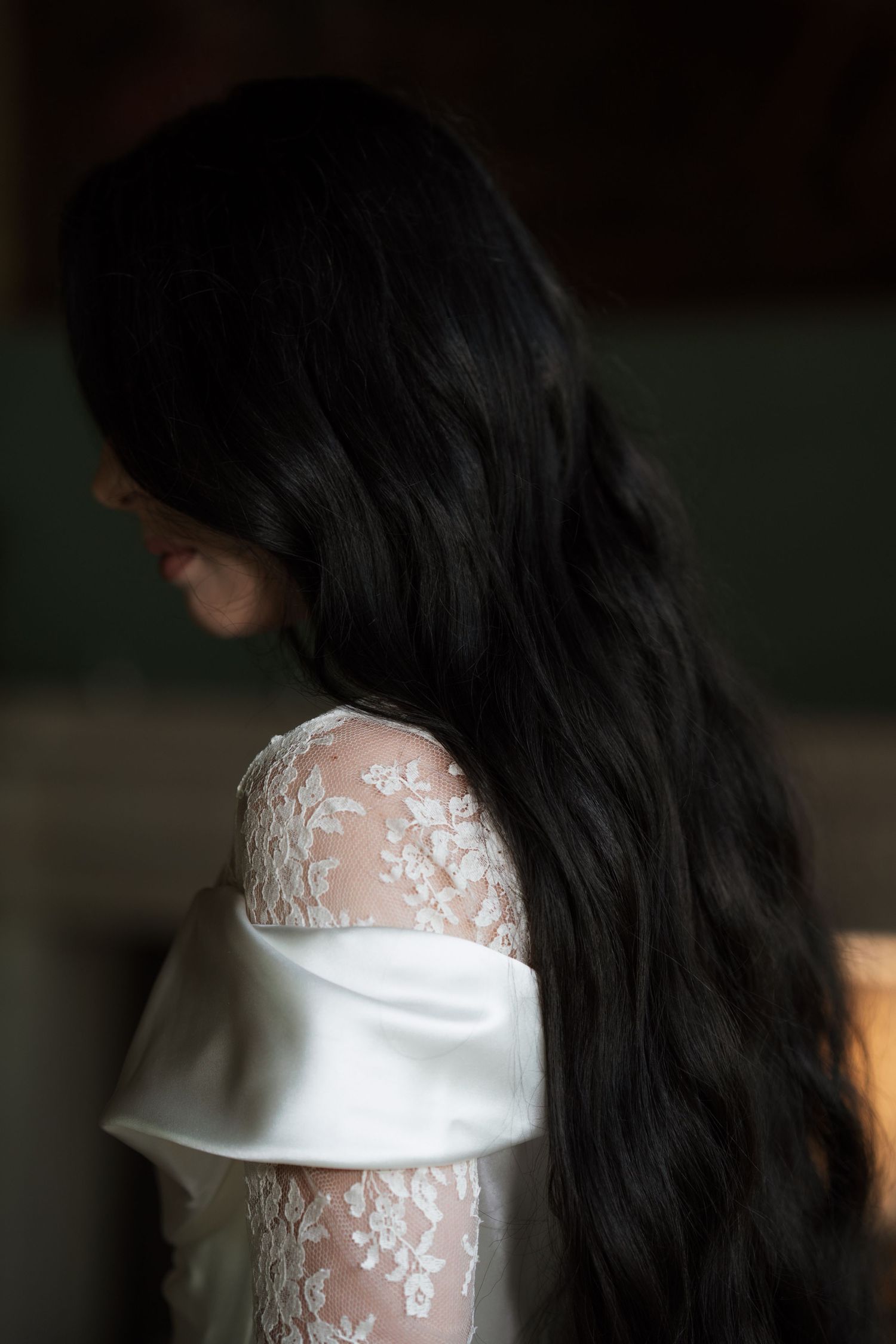 Side profile showing intricate lace details on a white wedding dress.