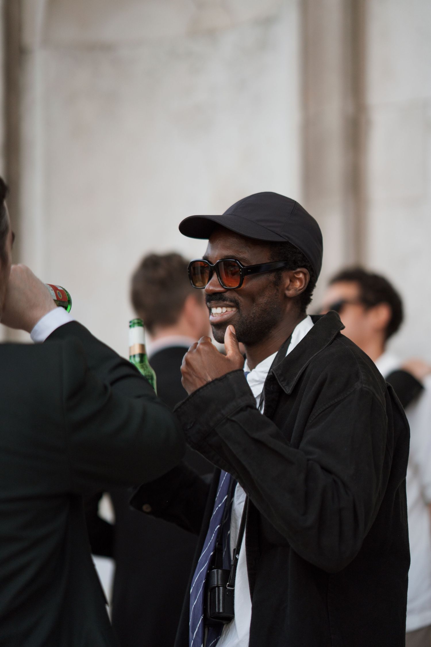 Event photographer wearing a black cap and suit taking photos.