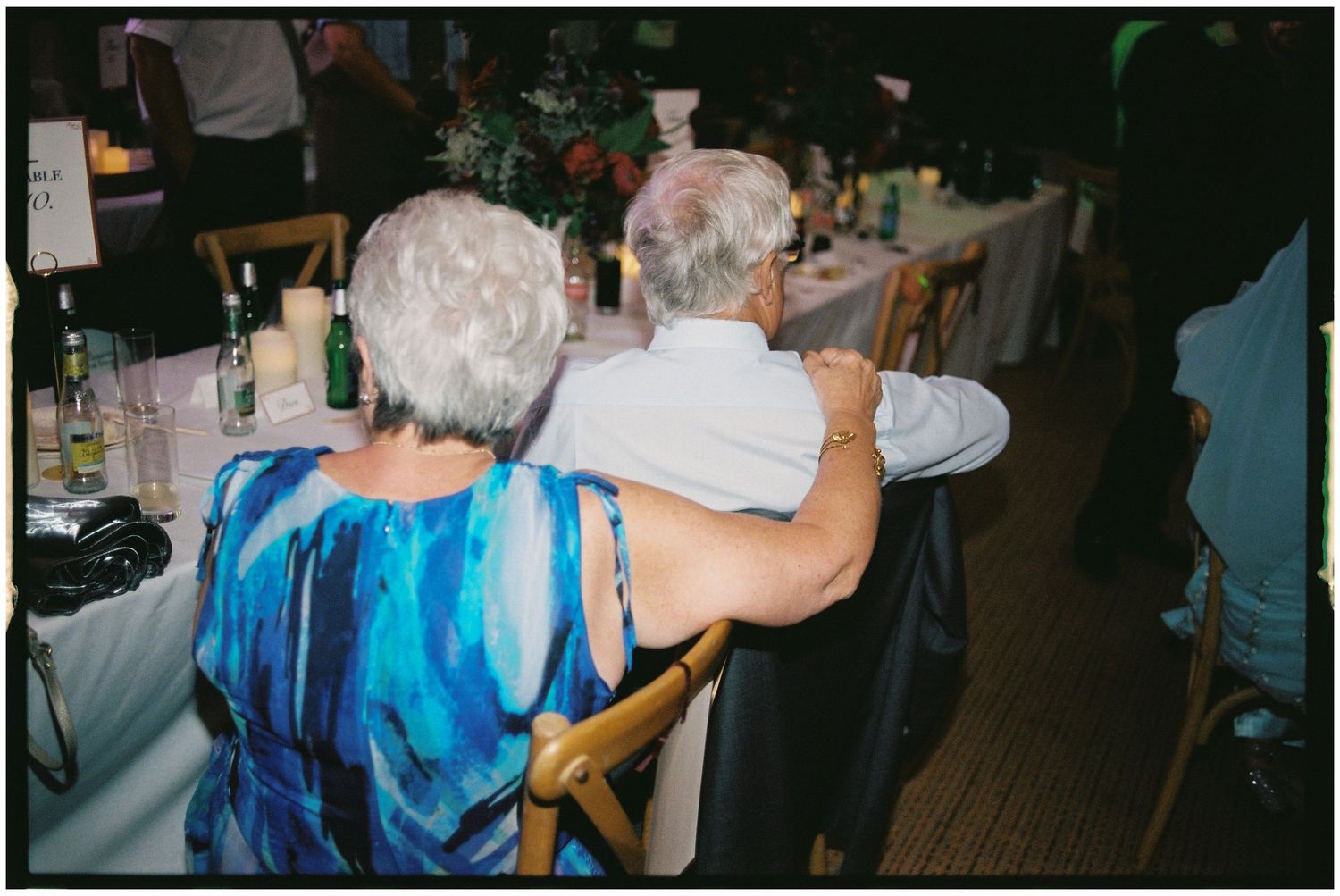 Wedding guests in blue attire enjoying the reception celebration.