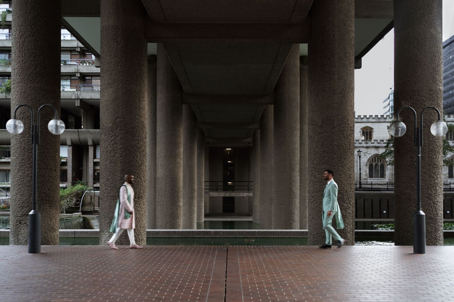 Wide architectural shot of a modern colonnade with distant figures.