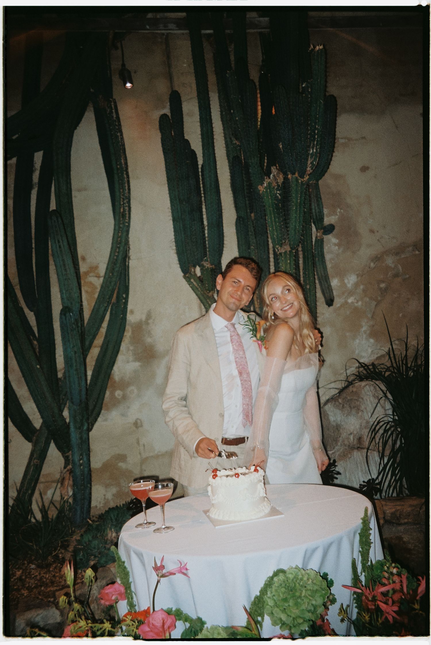 Couple enjoying drinks at a table surrounded by desert cacti.