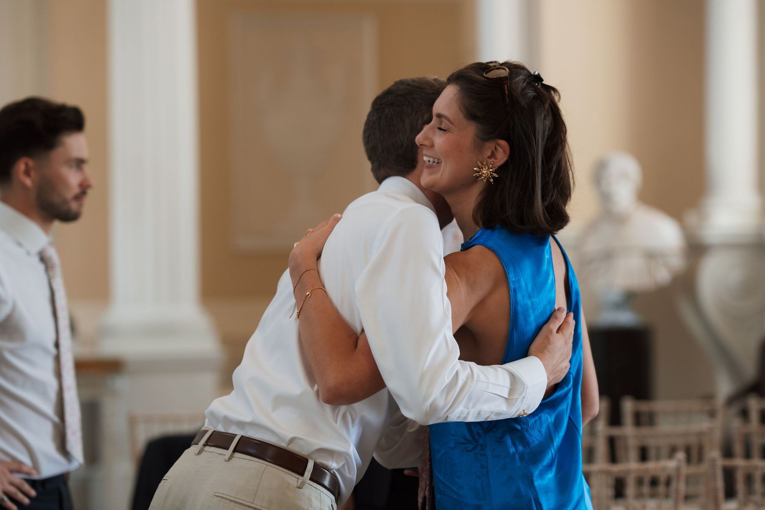 People dancing and celebrating at an elegant indoor venue with classical architecture.