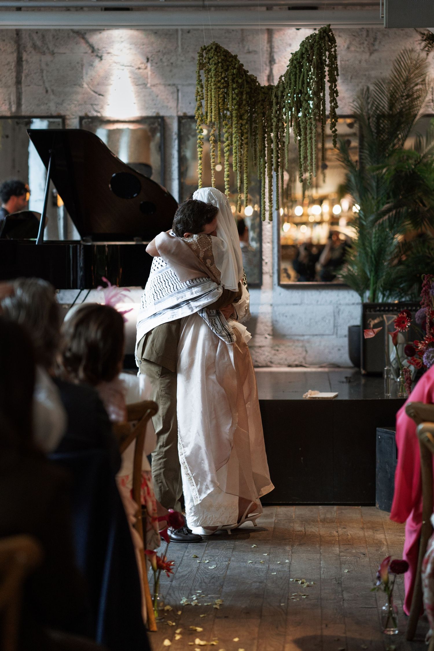 People mingling in an industrial-style venue with stone walls and hanging lights.