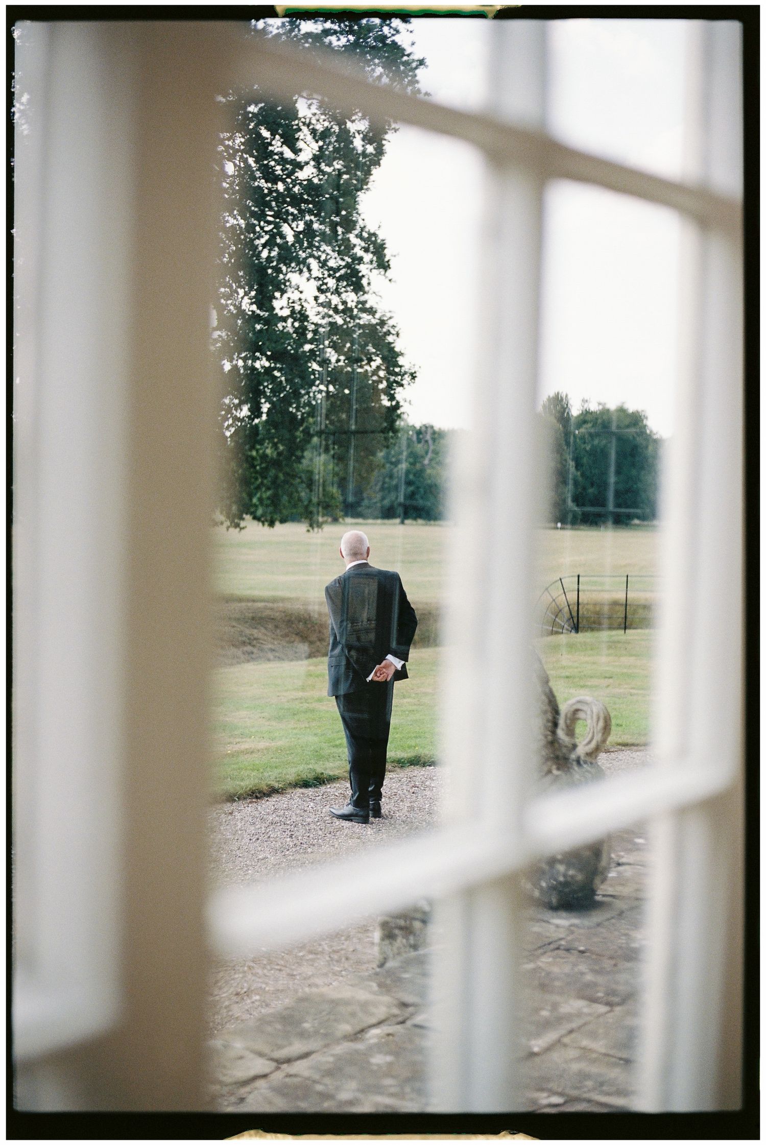 View through window panes of someone standing outside on grounds.