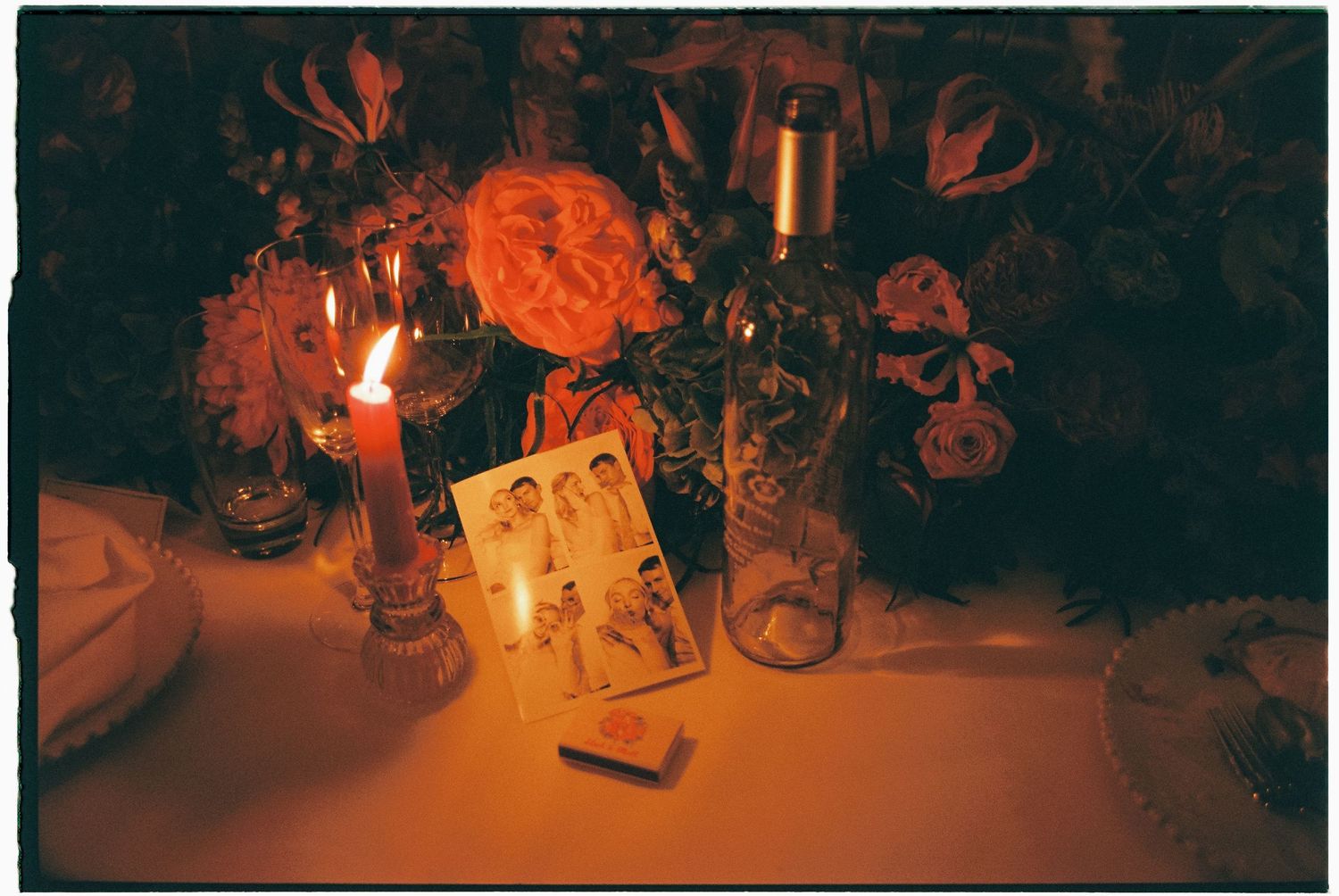Candles and decorative elements create a warm, romantic ambiance in a dark setting.