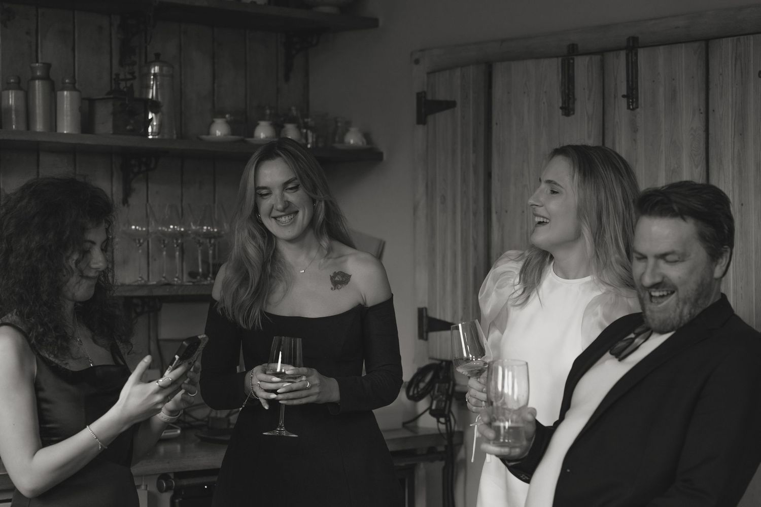 Black and white photo capturing laughter and joy at social gathering.