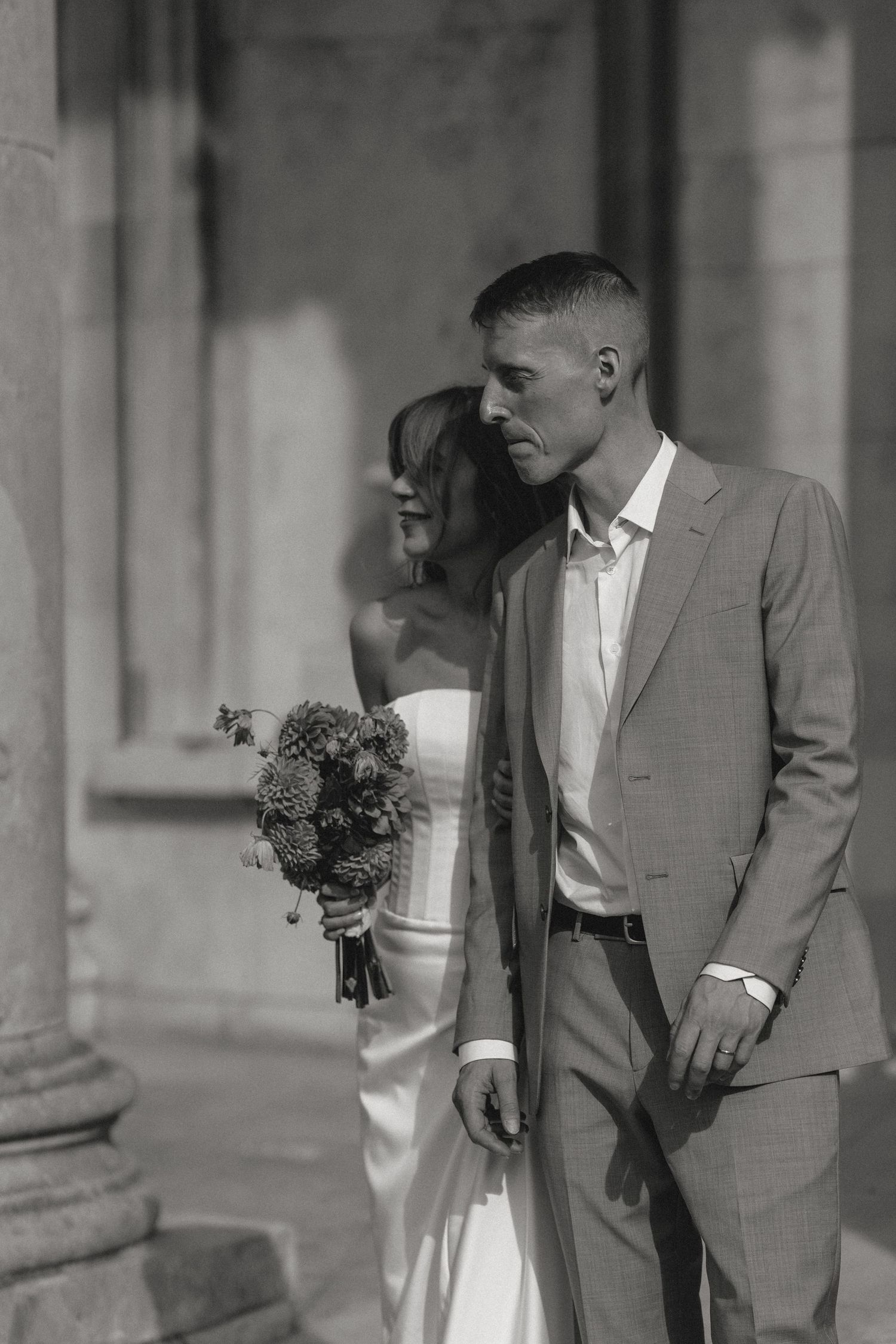 Artistic wedding portrait series showing couple against classical stone architecture.