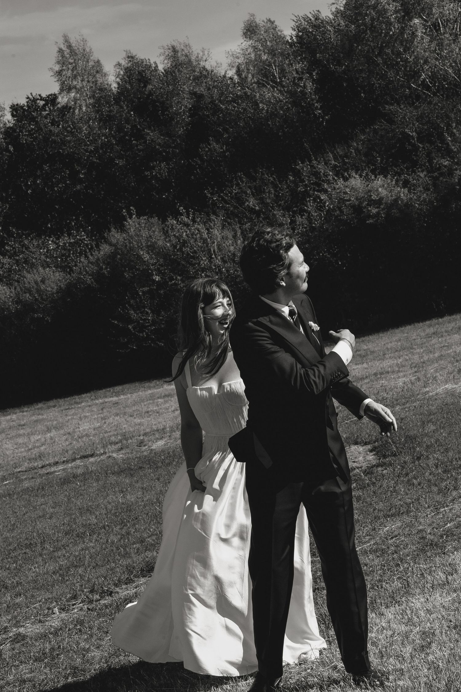 Wedding photoshoot sequence in black and white showing couple in a grassy field.