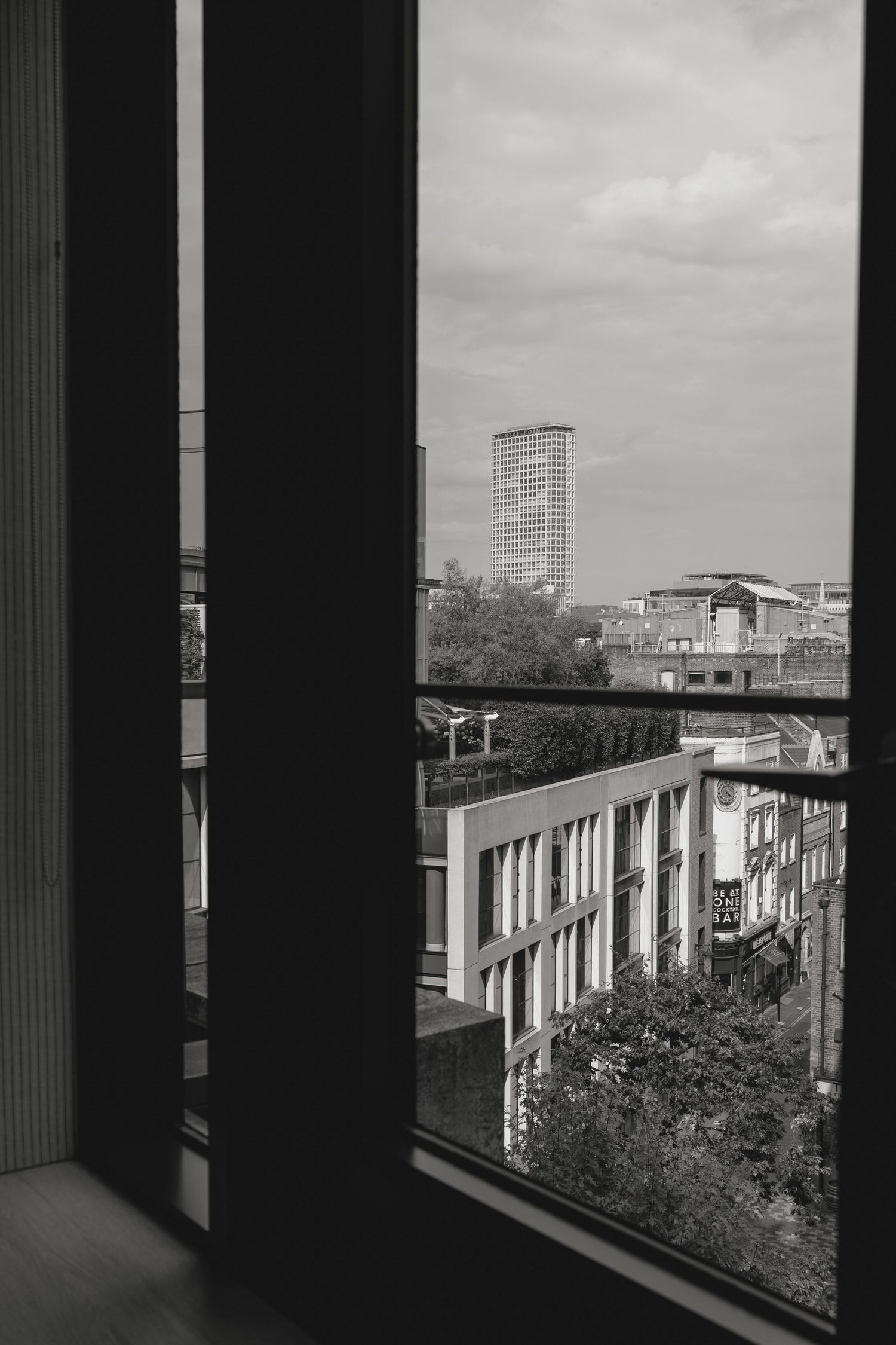 Black and white cityscape viewed through architectural columns.