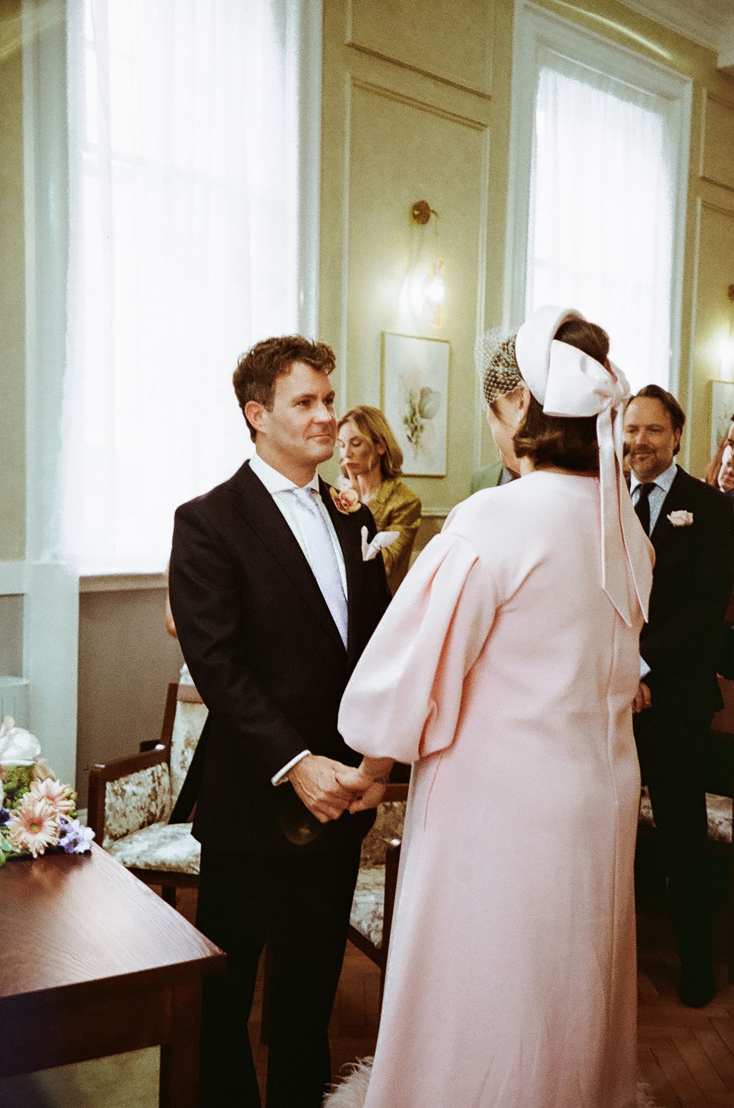 Wedding ceremony in a bright room with elegant decor and formal attire.