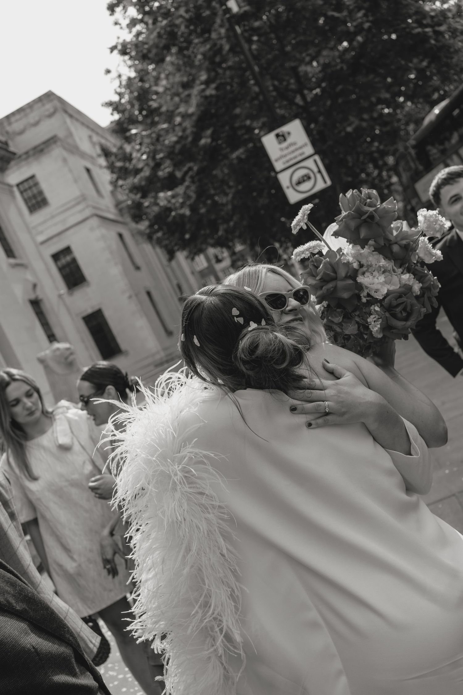 Black and white close-up of wedding dress with feather details.