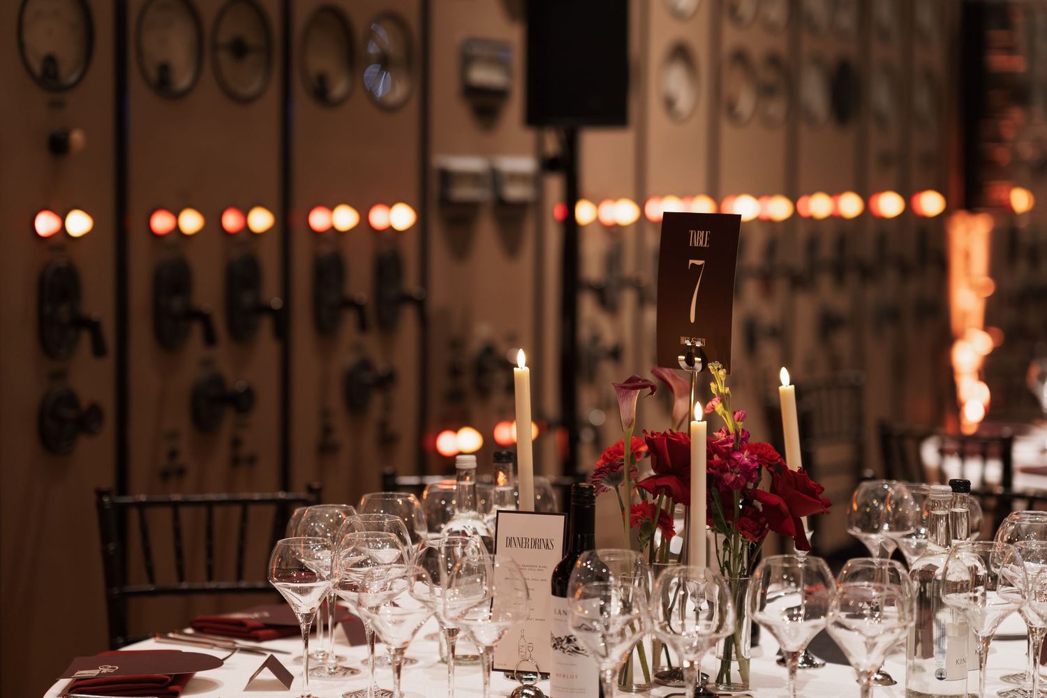 Romantic evening reception venue with elegant table settings and warm lighting.