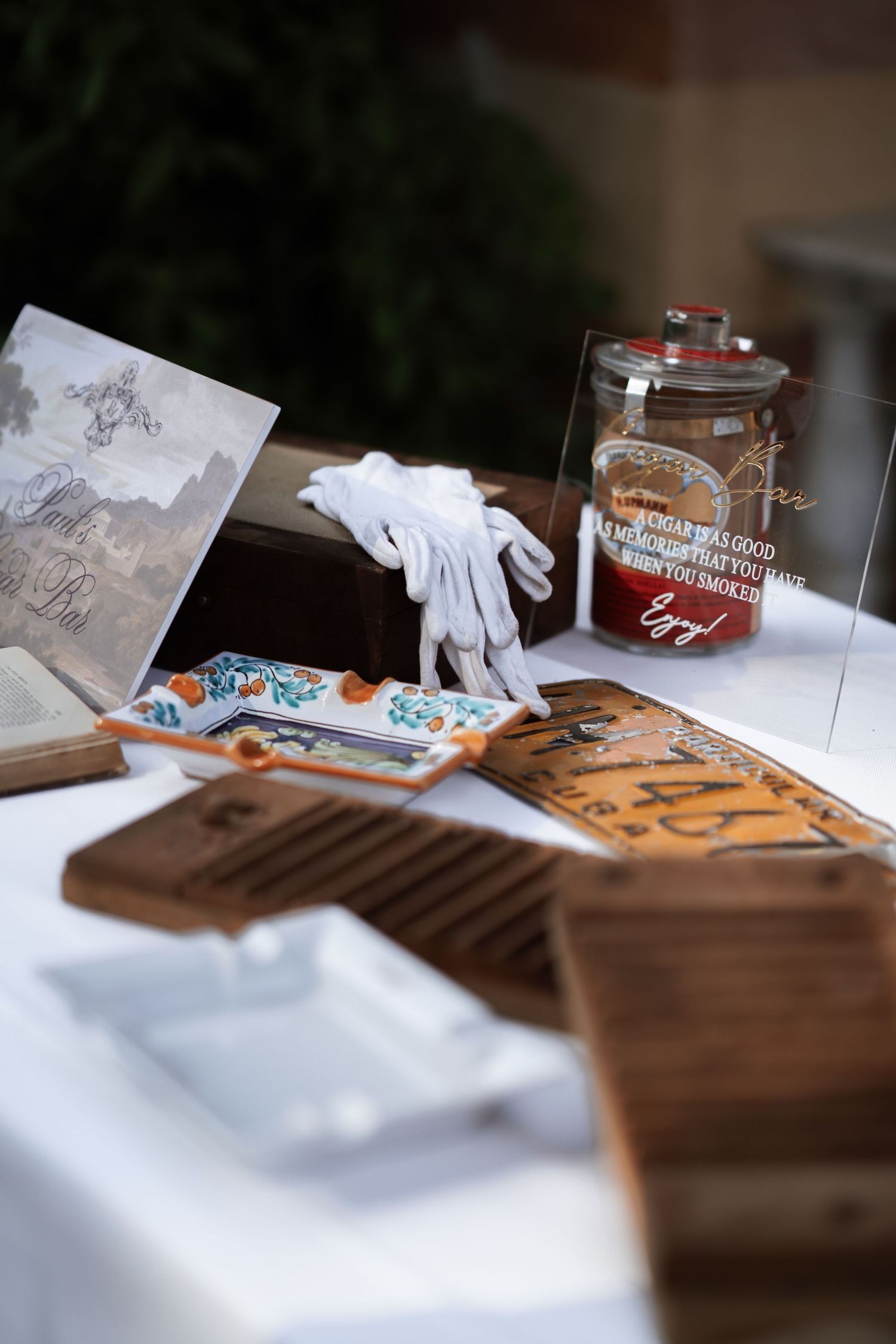 Wedding favor display with wooden boxes and decorative jars on a white tablecloth.
