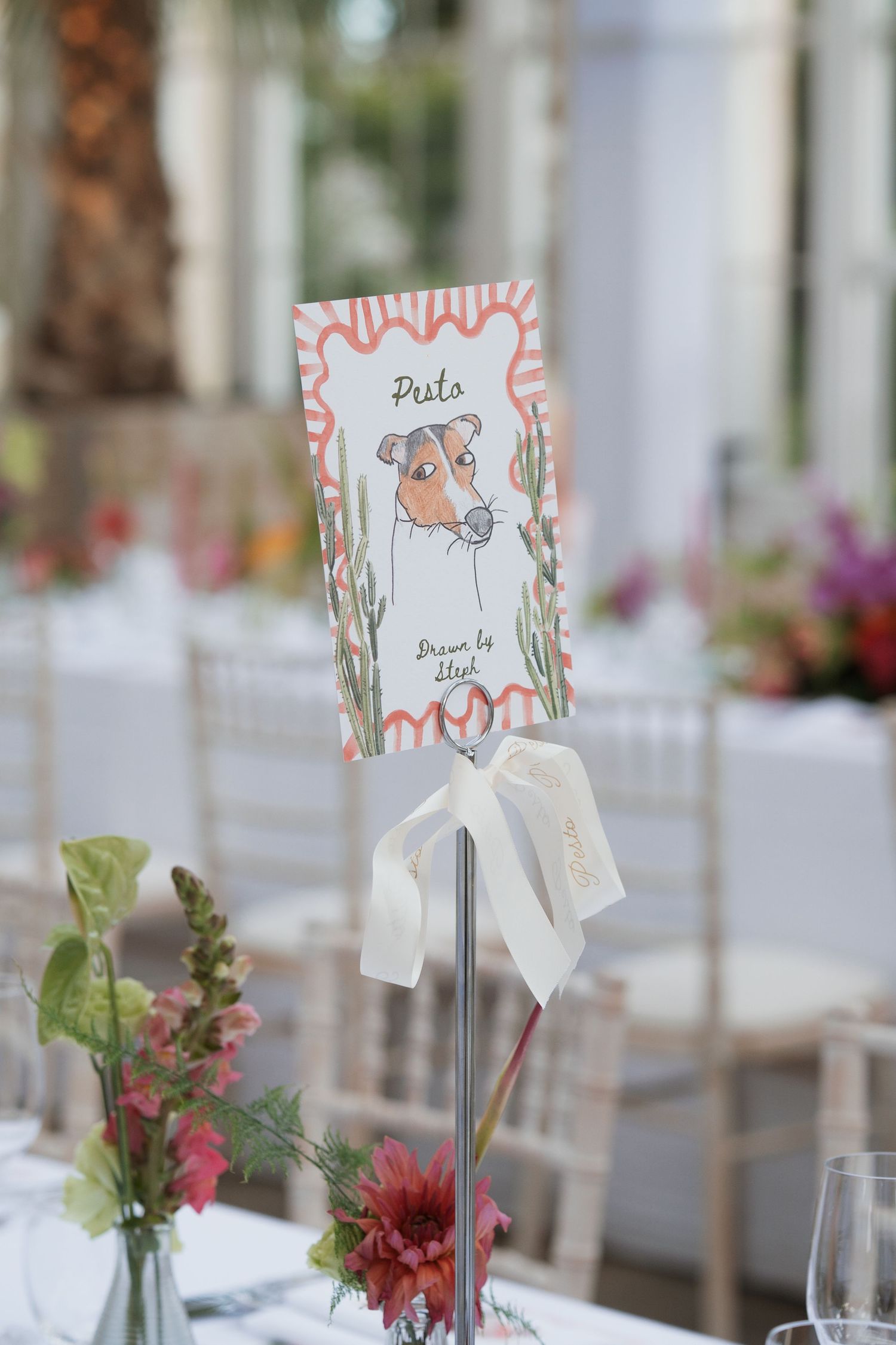 Wedding table settings with decorative name cards and small floral centerpieces.