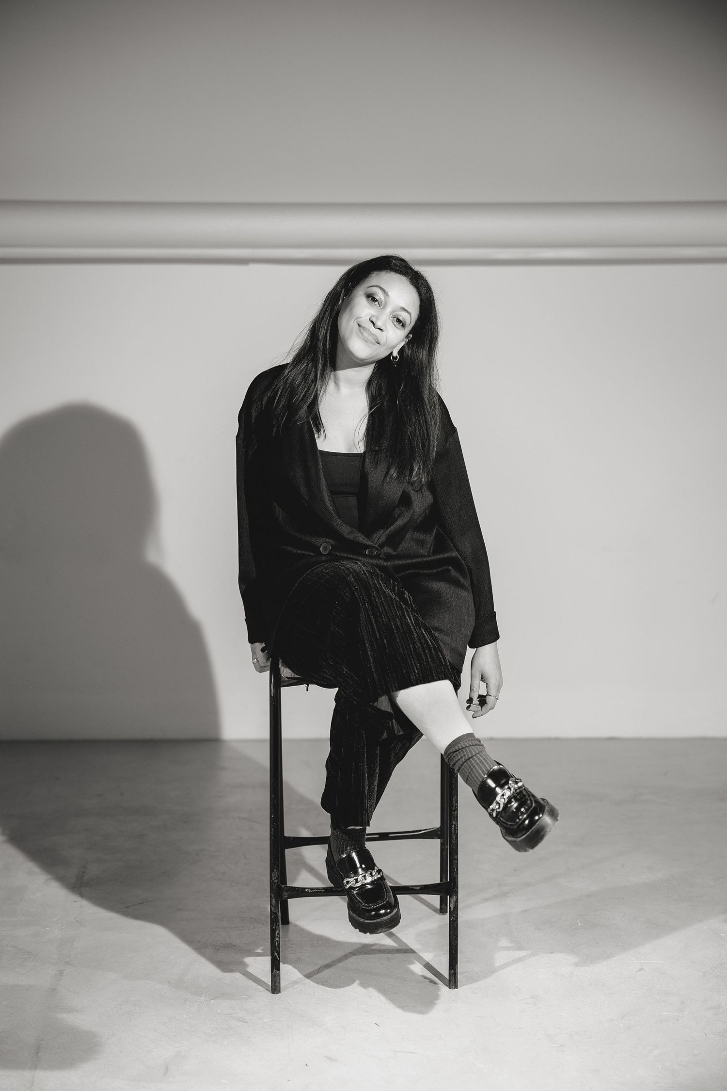 Monochrome photo sequence showing artistic poses on wooden chair with dramatic shadows.