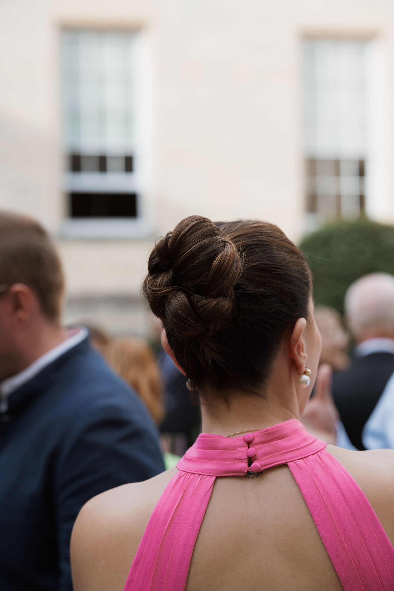 Group gathered outdoors wearing formal attire with pink halter dresses visible.