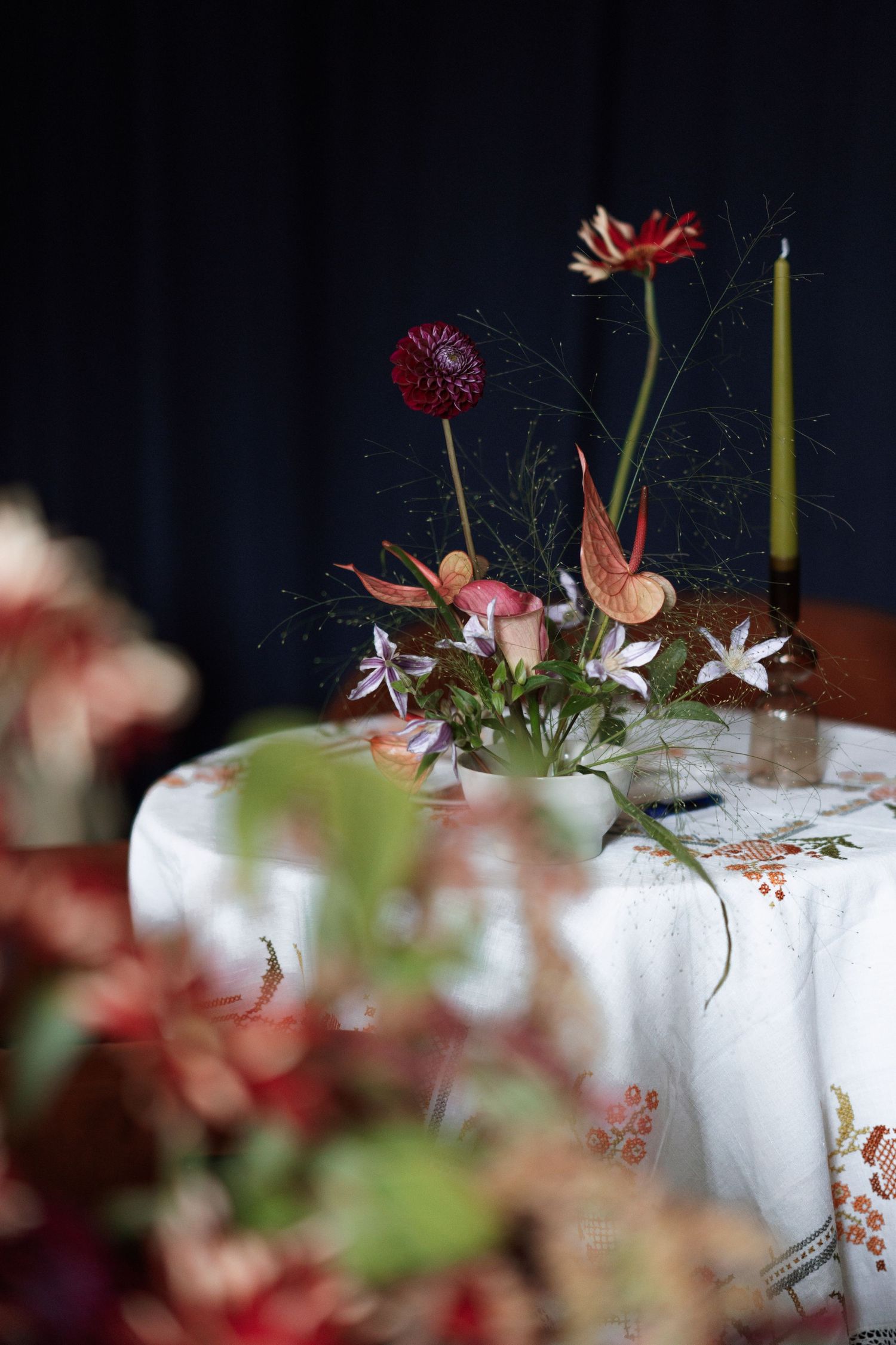 Elegant floral centerpieces on white tablecloths at formal event.