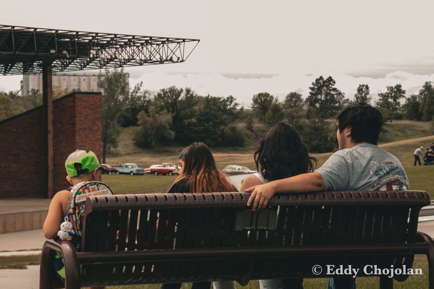 Group of friends relaxing on outdoor bench at sunset.